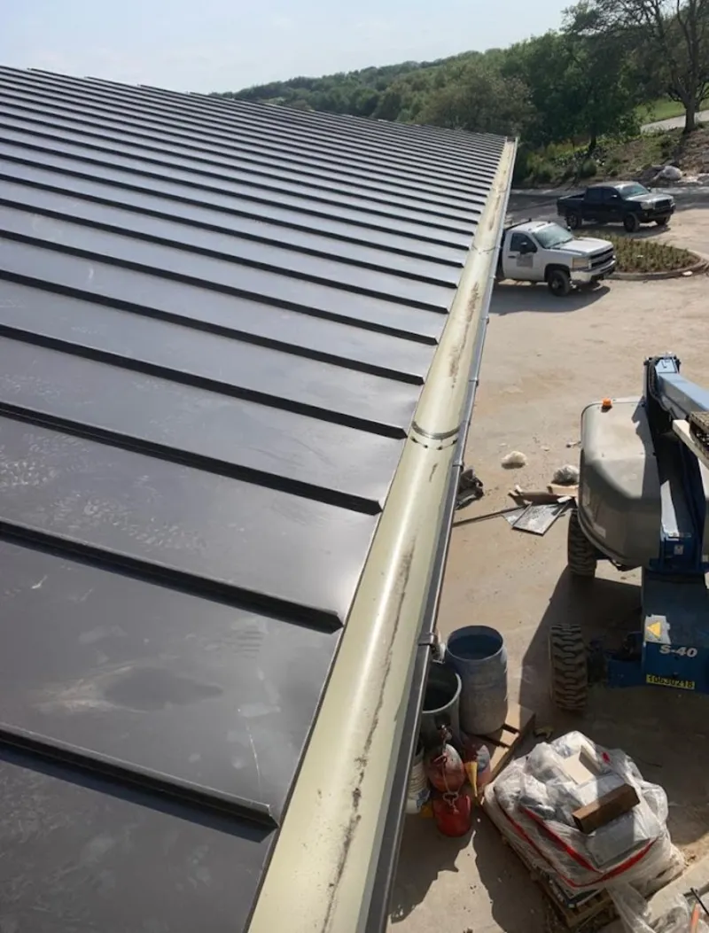 Standing seam panel and gutter detail on a metal roofing jobsite in Brenham
